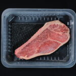 Packaged beef steak in a tray with an absorbent pad