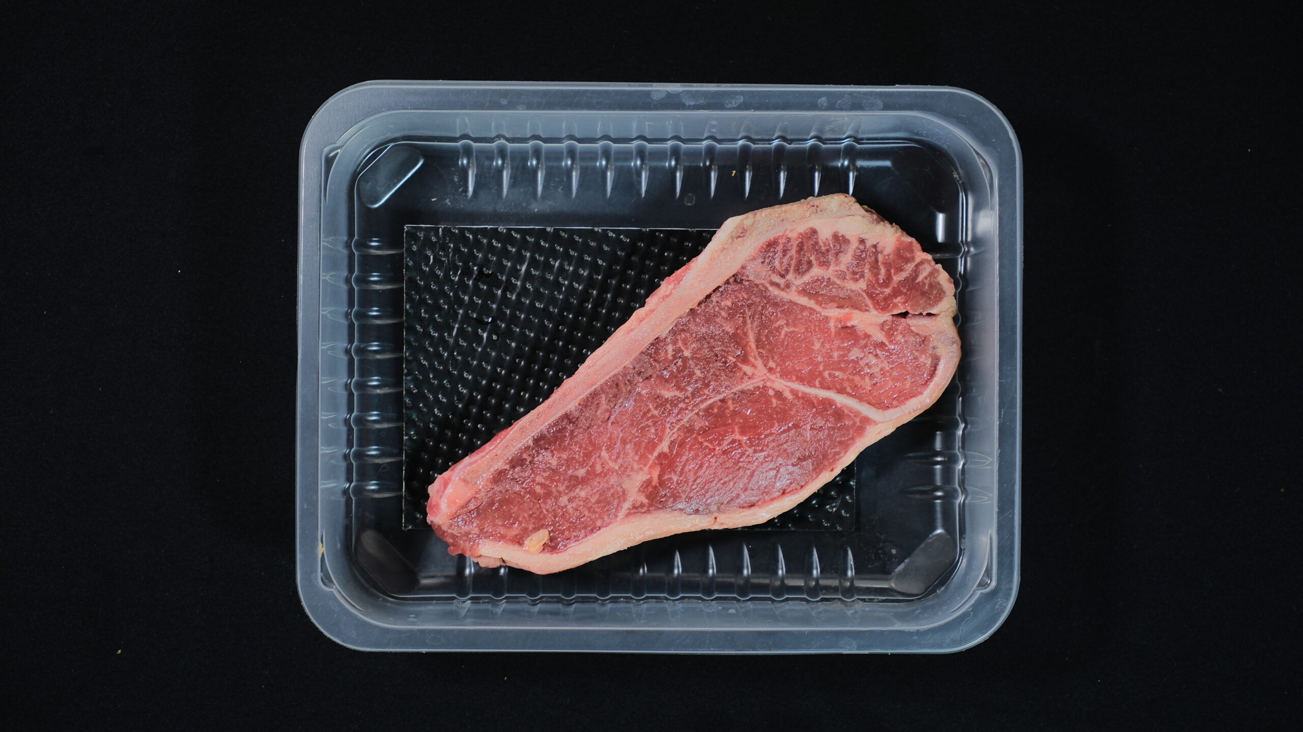 Packaged beef steak in a tray with an absorbent pad